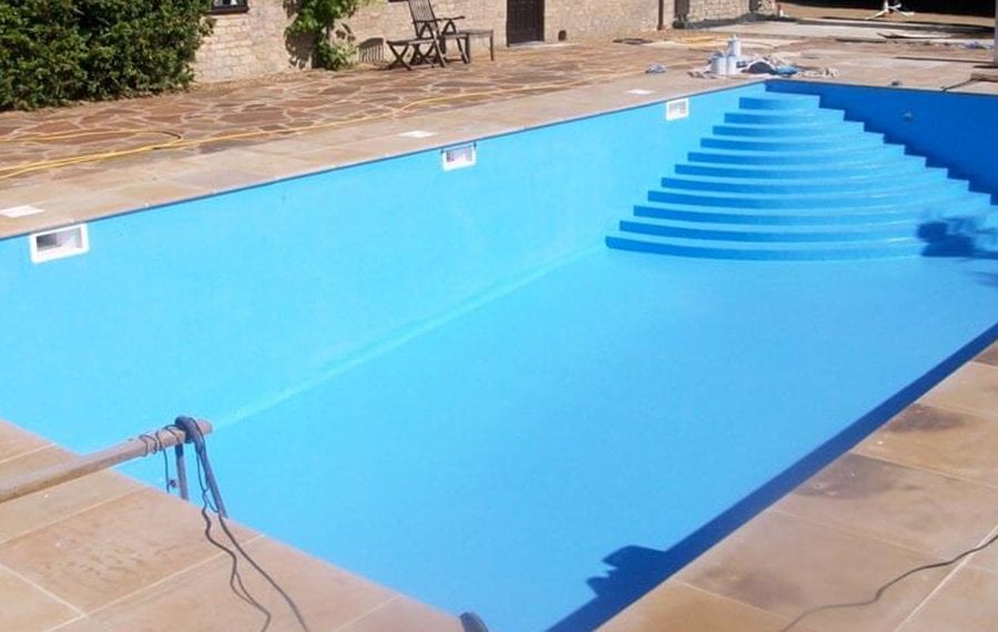 Merdivenli beton yüzme havuzunda mavi havuz boyası uygulaması